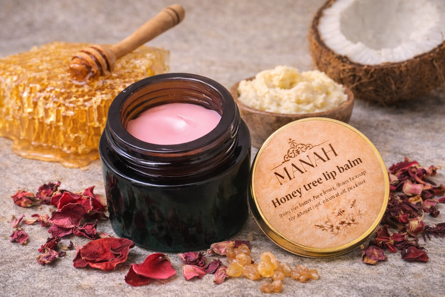Open jar of Manah Honey Tree Lip Balm surrounded by raw honeycomb, dried rose petals, coconut, and Mahua butter, highlighting its all-natural, honey-based, deeply moisturising, chemical-free formulation.
